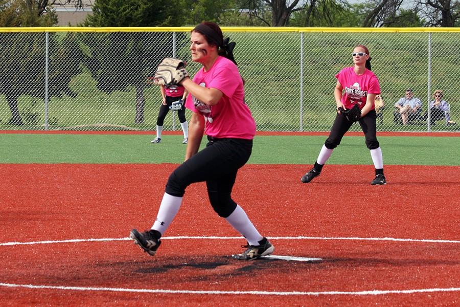 Lexi Storrer, junior, winds up a pitch during the varsity  Pink Night game against Olathe Northwest to support breast cancer awareness. 