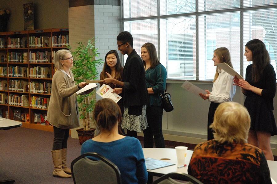Khadija Ceesay, freshman, accepts her first place award from Mimi Rainen, contest coordinator, at the Kansas Region 7 Poetry Out Loud contest.