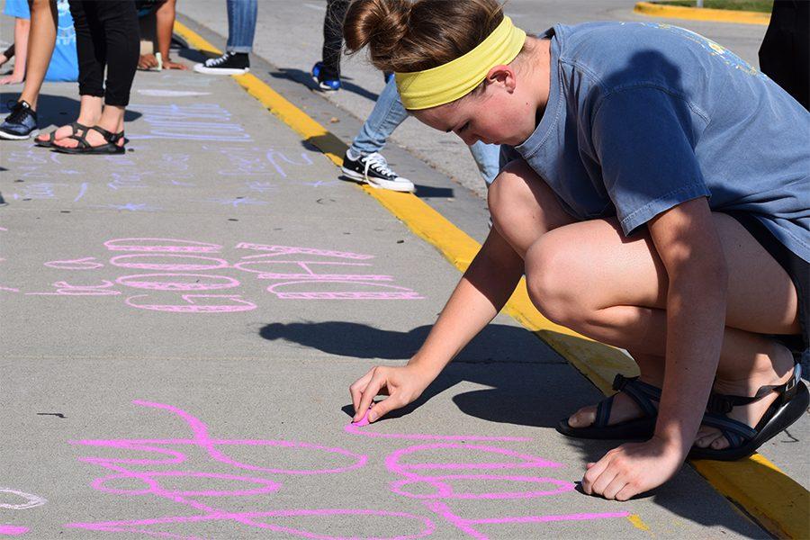 Ellie Bickley writing words of encouragement with the Falcon Service Club during the Kindness with Chalk event on Oct. 3.