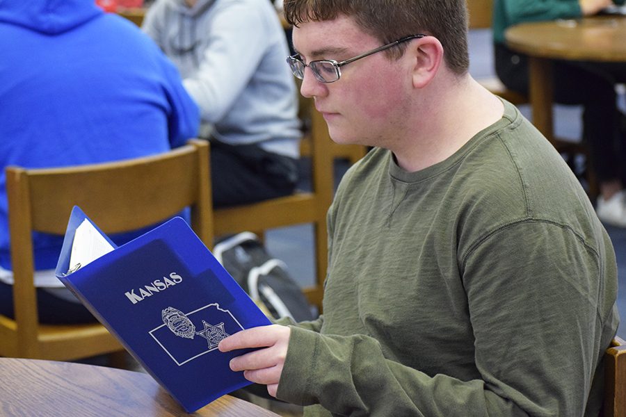 Patrick Grey reading the mantra for mock trial practice in the library February 8th.