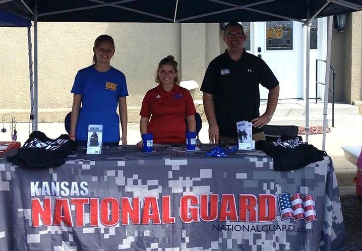 Breanna Salsmonson, senior, at a stand with two other National Guard members advertising for the National Guard itself.