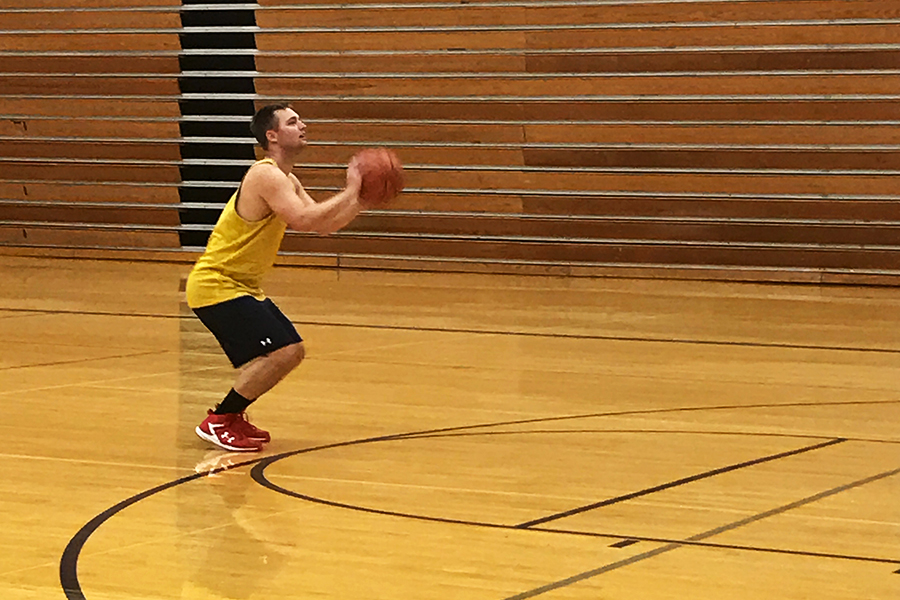 A graduated student shooting baskets at the alumni basketball tournament on April 14