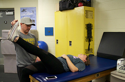 Dennis Dolan working with Danielle Peters, sophomore, who hurt her back playing soccer.