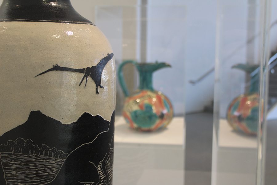 The vase is covered in scenes of prehistoric nature, all painted black. This includes painted trees, mountains and a Pterodactyl.