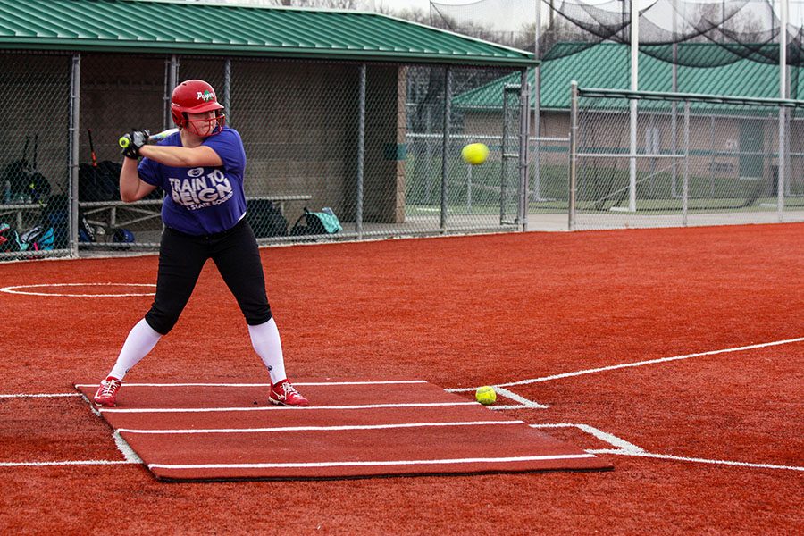 Alyssa Owens, junior, about to hit the ball. Her coach, Mike Allen, threw towards her during softball practice.