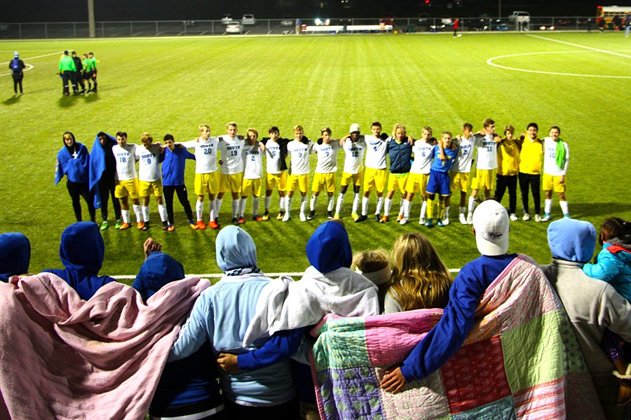 The soccer team shares a moment with the crowd at a game.