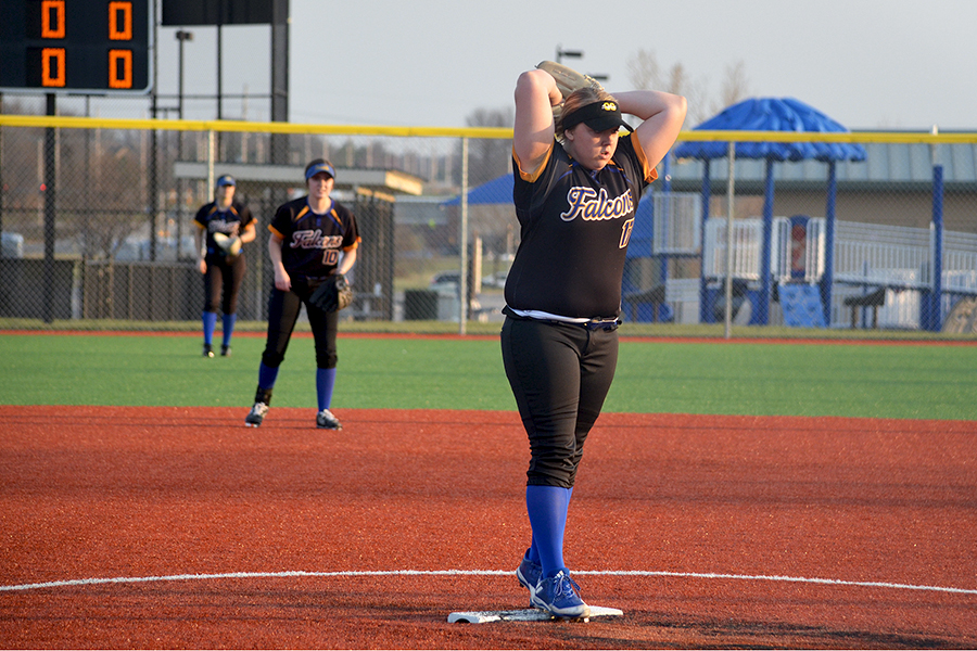 Maryssa Rollin, senior, in the windup prepared to devliver a pitch at CBAC for the softball team on April 5 against Olathe West. As the starting pitcher, lots of pressure rests on Rollin to do well. Other players stood at the ready in the background, prepared to jump into action if the hitter sent the ball their way. Shortstop also must be ready if a player at first attempted to steal second base, working with the second baseman and catcher to prevent a base from being stolen.