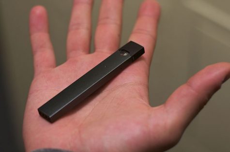 A Juul vaping device in a hand. The Olathe School District decided to set a precedent for other school districts by suing the electronic cigarette tycoon.