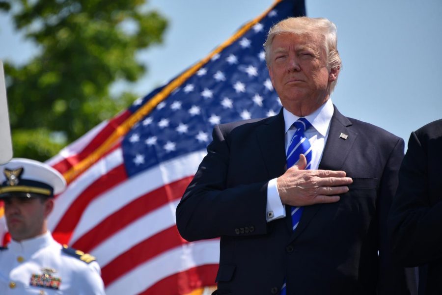 President Donald Trump, pictured holding his right hand over his heart to respect the American flag. Trump was investigated to see if he was eligible to be impeached and removed from the presidency.