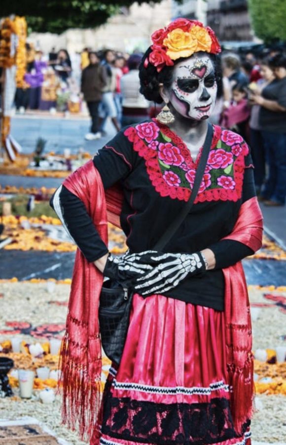 A woman dressed in traditional Day of the Dead attire participates in a celebration in Morelia, Mexico. The Day of the Dead is a traditional multi-day Mexican holiday which gathers families to honor their deceased family members and commemorate them with a decorated altar.