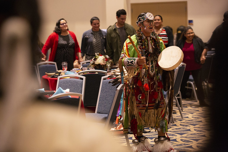 A performer at the 2019 Native American Heritage Month Celebration and Recognition event at California State University shows the crowd music, instruments and clothing from his culture.