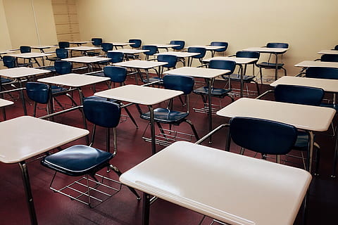 image of empty classroom full of desks taken by Piqsels