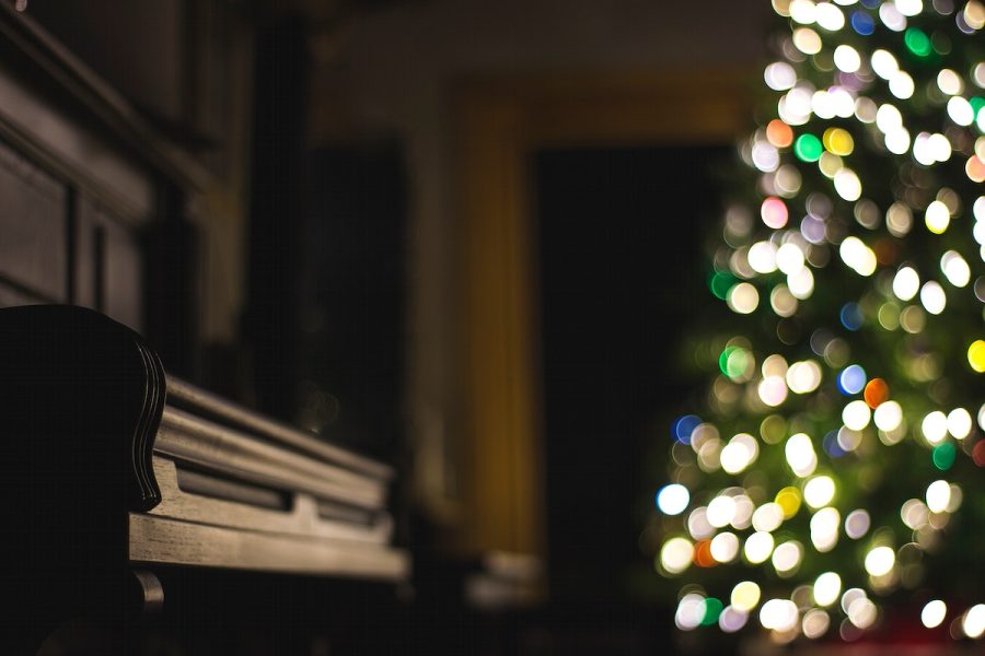 A+dim+shot+of+a+piano+next+to+a+Christmas+tree+with+bokeh+effect.+Original+public+domain+image+from+Wikimedia+Commons