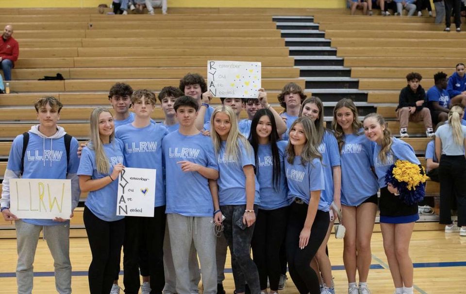 Students crowd together to display their LLRW t-shirts and signs made to commemorate Ryan Whitney.