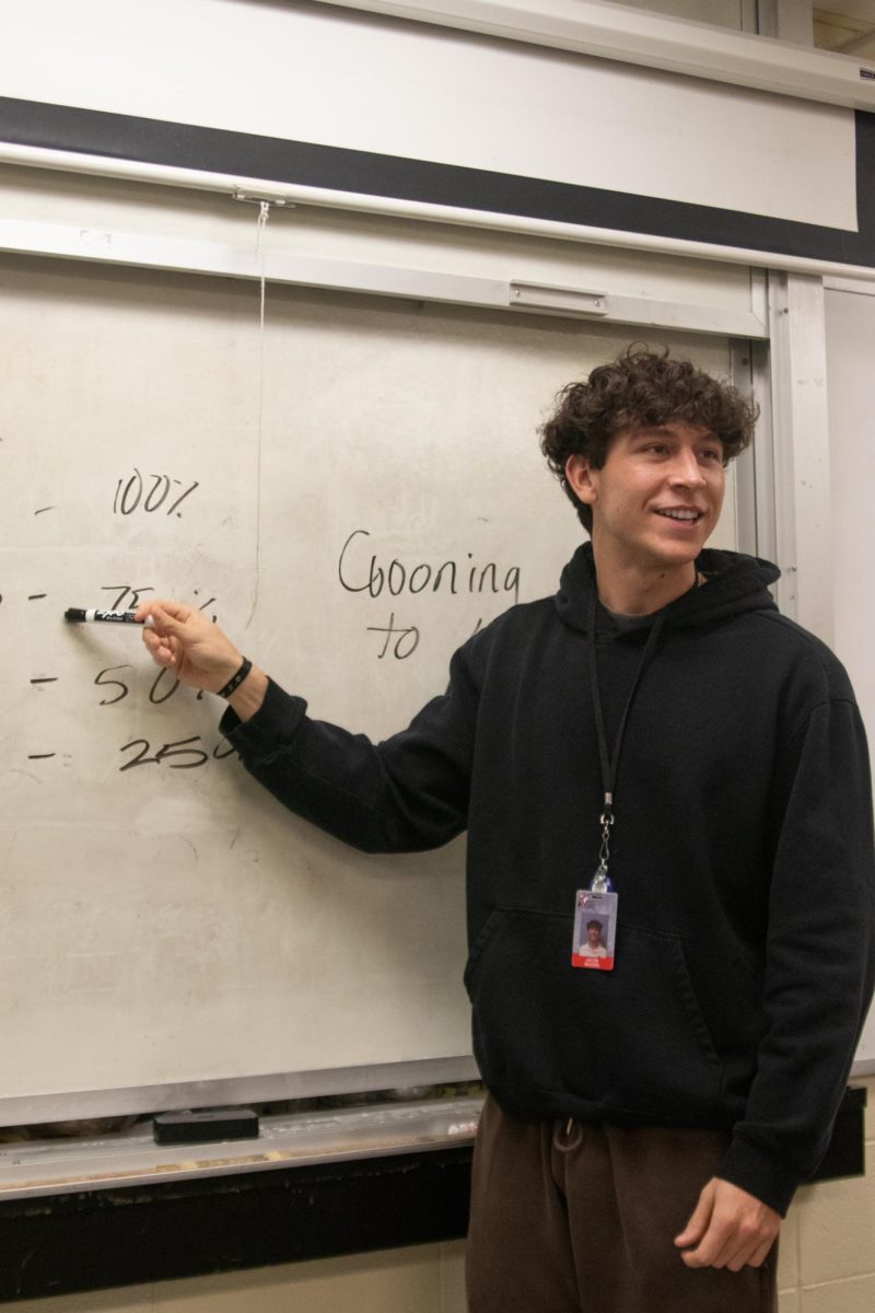 Mr. Waters teaches his students how percentages in class work.